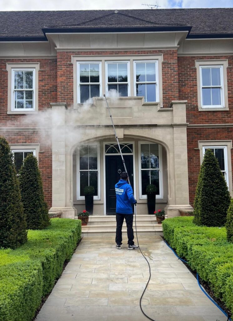 Pristine Exterior Cleaning steam cleaning a stone house front in Surrey